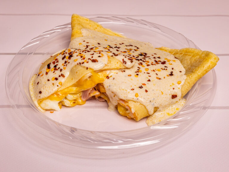 Savory breakfast crepe folded with ham, egg and melted cheese